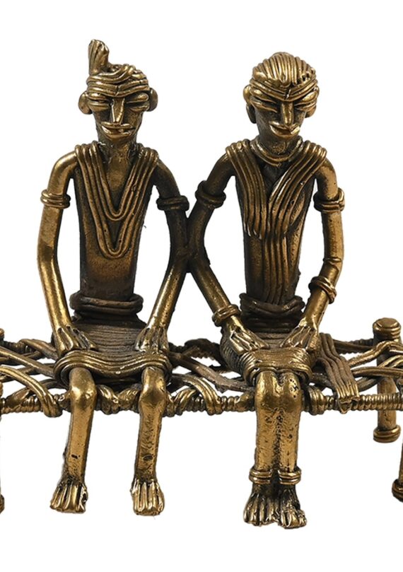 Dhokra couple sitting on cot- bed
