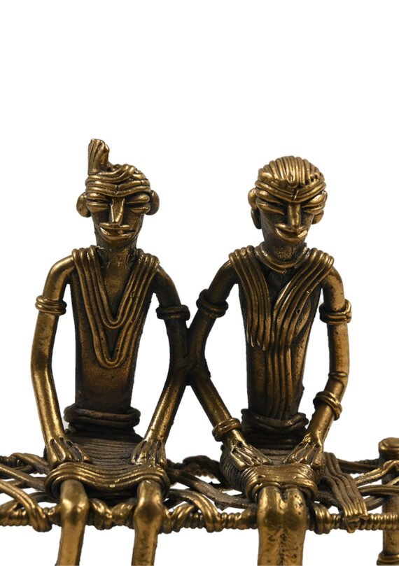 Dhokra couple sitting on cot- bed